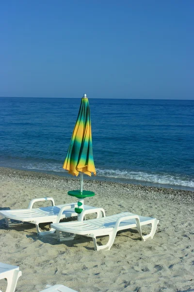 Gevouwen paraplu op een strand — Stockfoto