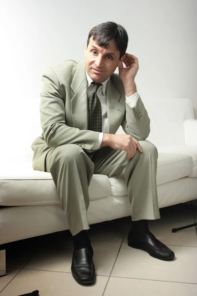 Businessman on a white leather sofa — Stock Photo, Image