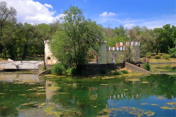 写真はウクライナのオデッサ市の庭で撮影されました 池の真ん中にある島の城の形で放棄された古い建物を示しています — ストック写真