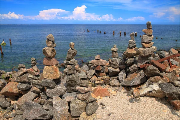 The photo was taken on a public beach in the city of Odessa. The picture shows an artificial heap of stones in the form of towers and pyramids on the Black Sea coast.