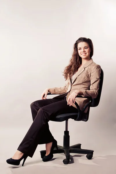 Bir ofis sandalye üzerinde oturan kadın — Stok fotoğraf
