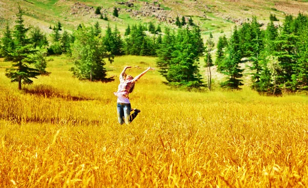 Girl jumping on wheat field — Stock Photo, Image