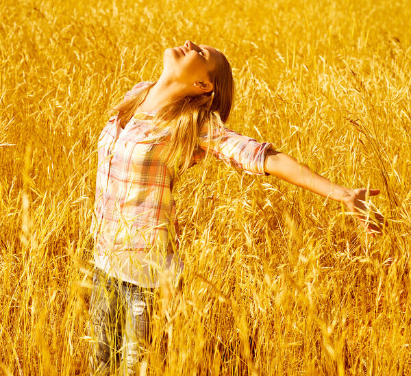 Girl on autumn wheat field