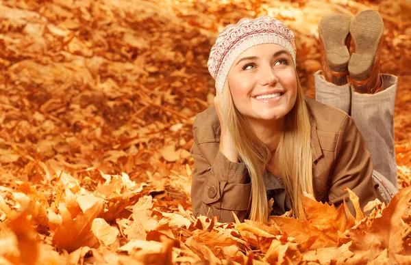 Girl lying down on autumnal leaves — Stock Photo, Image