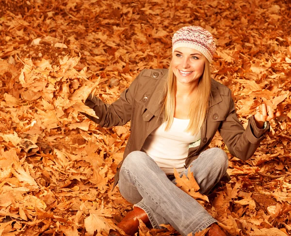 Meisje overgeven herfst bladeren — Stockfoto