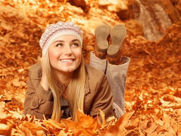 Woman lay down on autumnal foliage — Stock Photo, Image