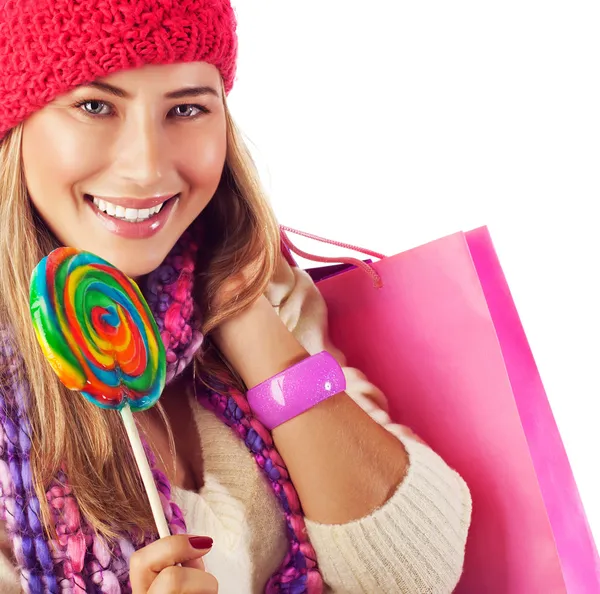 Menina lamber doces e segurando saco rosa — Fotografia de Stock