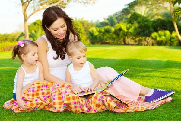 Mère avec des enfants lire le livre — Photo