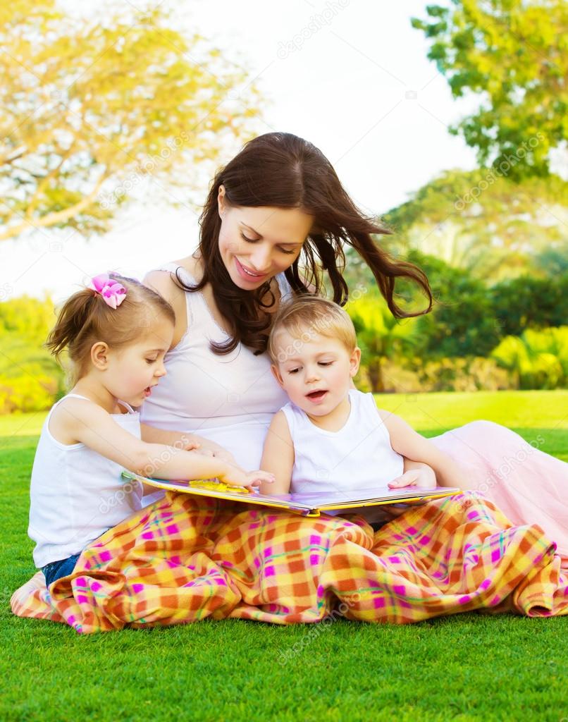 Happy family reading outdoors
