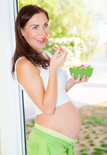 Menina grávida comendo salada — Fotografia de Stock