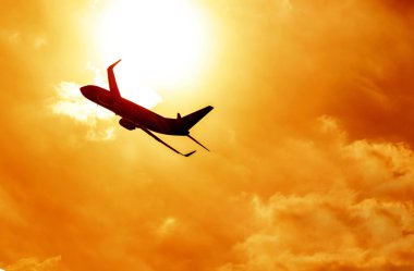 Airplane silhouette on sunset background clipart
