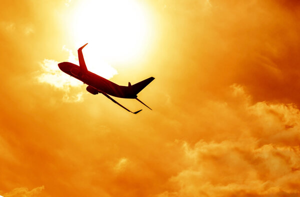 Airplane silhouette on sunset background