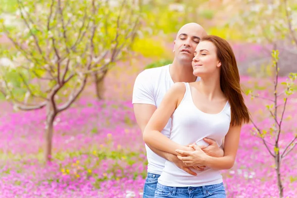 Loving family hugging in spring park — Stock Photo, Image