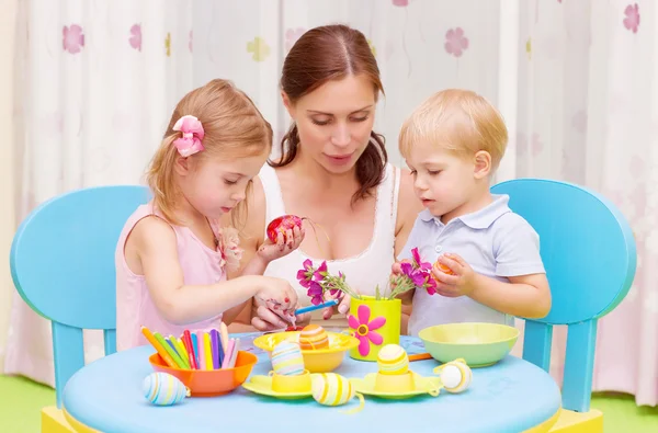 Mother with kids paint Easter eggs — Stock Photo, Image