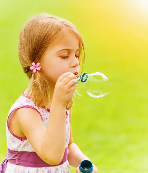 Дитяча дівчинка дме мильні бульбашки — стокове фото