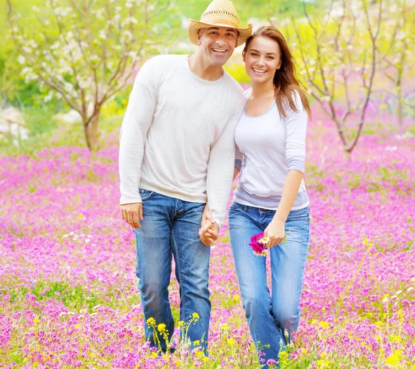 Junge Familie geht im Garten spazieren — Stockfoto