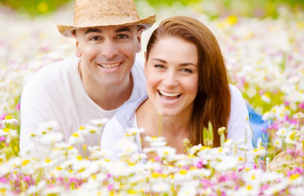 Happy couple on daisy field — Stock Photo, Image