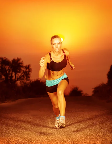 Mulher desportiva correndo no pôr do sol — Fotografia de Stock