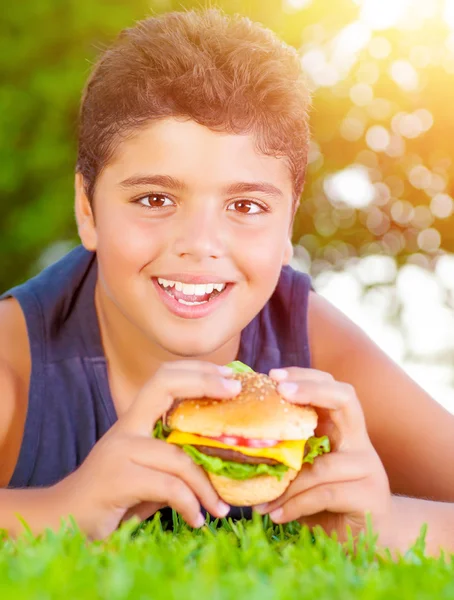 Arap çocuk yeme hamburger açık havada — Stok fotoğraf