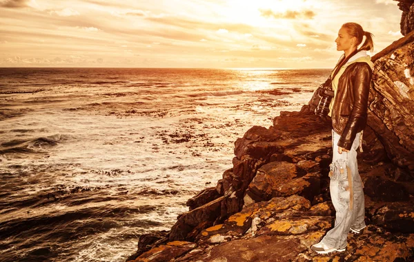 Туристична дівчина на заході сонця на скелі — стокове фото