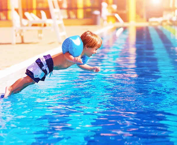 Menino pequeno pulando para a piscina — Fotografia de Stock