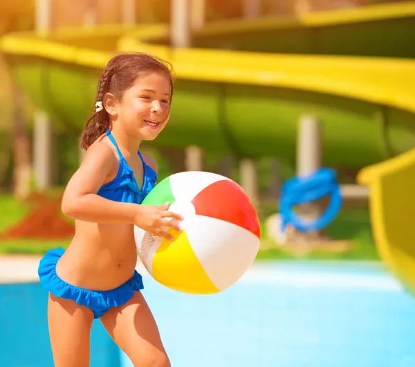 Meisje met bal in de buurt van zwembad — Stockfoto