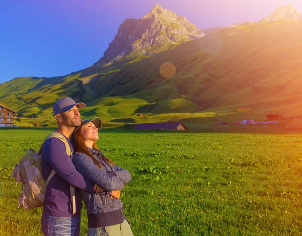 Pareja cariñosa disfrutando de la puesta de sol en las montañas — Foto de Stock