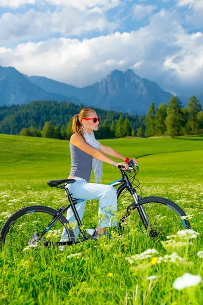 Mujer activa en bicicleta en las montañas — Foto de Stock