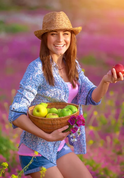 Gelukkig meisje met mand met appelen — Stockfoto