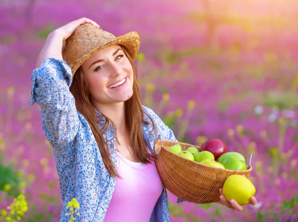 Jolie femme avec panier de pommes — Photo