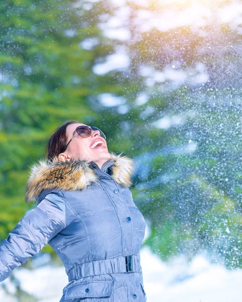 Счастливая женщина бросает снег — стоковое фото