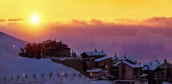 Hermosa puesta de sol en el pueblo montañoso nevado —  Fotos de Stock