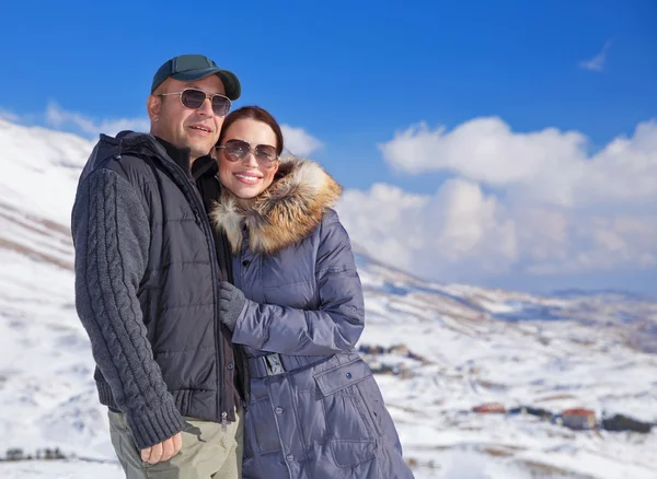 Loving couple in snowy mountains — Stock Photo, Image