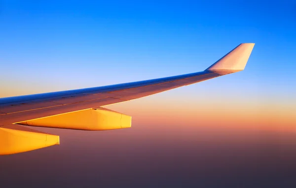 Křídla letadla v západu slunce světlo — Stock fotografie