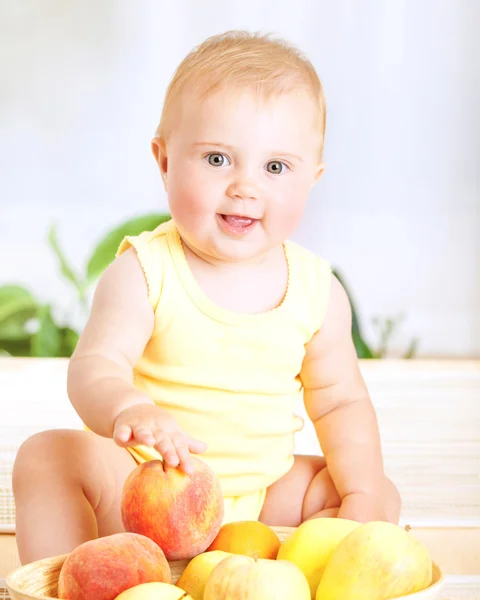 Schattige baby met vruchten — Stockfoto