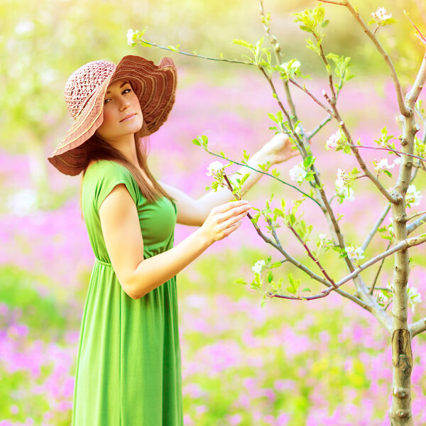 Dreamy girl relaxing in beautiful spring garden, gentle blooming nature, tender fresh flowers, sensuality concept