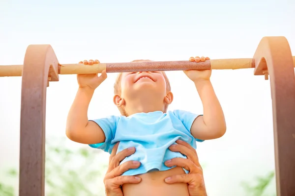 Little boy catch up on the horizontal bar — Stock Image Little boy catch up on the horizontal bar Stock Picture
