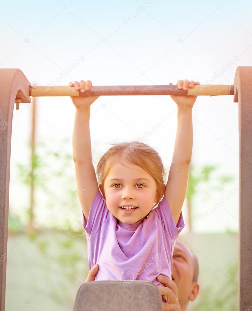 Happy child lifting on crossbar