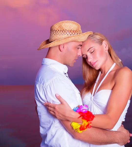 Casal feliz desfrutando do pôr do sol na praia — Fotografia de Stock