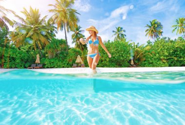 kadın suya sahilde geliyor.