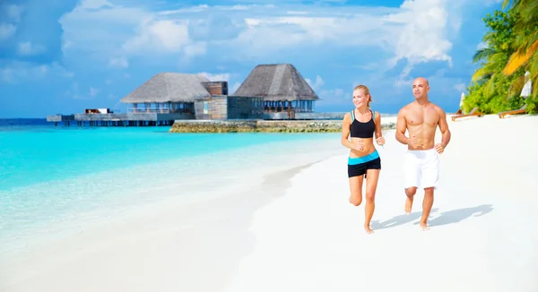 Счастливая пара бегает по пляжу — стоковое фото