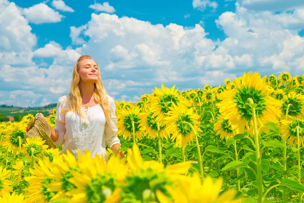 Frau im Sonnenblumenfeld — Stockfoto