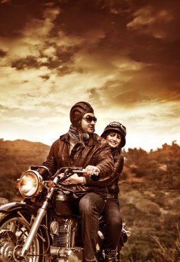 Happy motorcyclists in sunset clipart