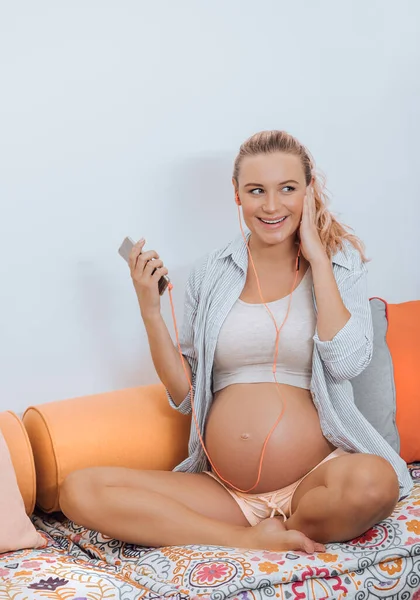 Gravid kvinna lyssnar musik — Stockfoto