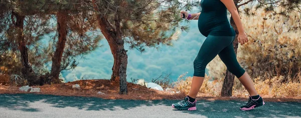 Kobieta w ciąży, jogging w parku — Zdjęcie stockowe