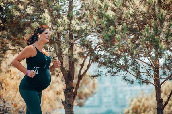 Kobieta w ciąży, jogging w parku — Zdjęcie stockowe