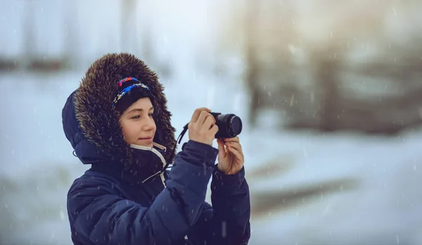 Jeune femme prenant des photos en chute de neige — Photo