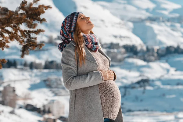 Ευτυχισμένη έγκυο γυναίκα που απολαμβάνει το χειμώνα — Φωτογραφία Αρχείου