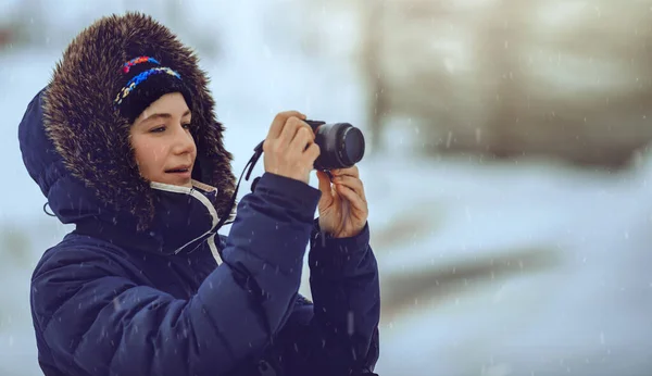 Jeune femme prenant des photos en chute de neige — Photo