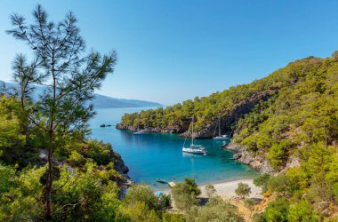 Beautiful Landscape of a Backwater Between Mountains Covered with Green Forest. Sailboat Floating in Lagoon. Amazing Beauty of Turkey.